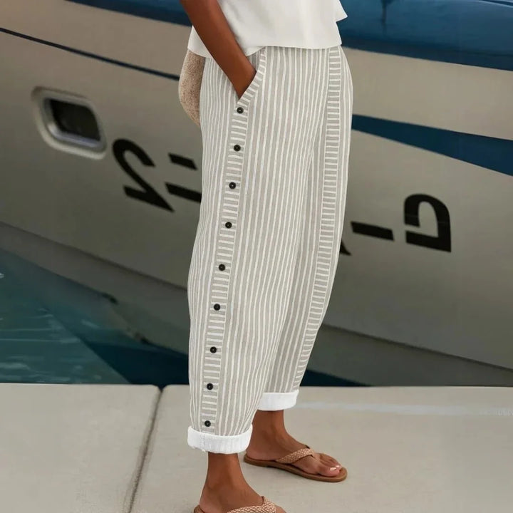 Mode femme : pantalon à rayures fines avec boutons stylés. Idéal pour un look élégant et printanier.