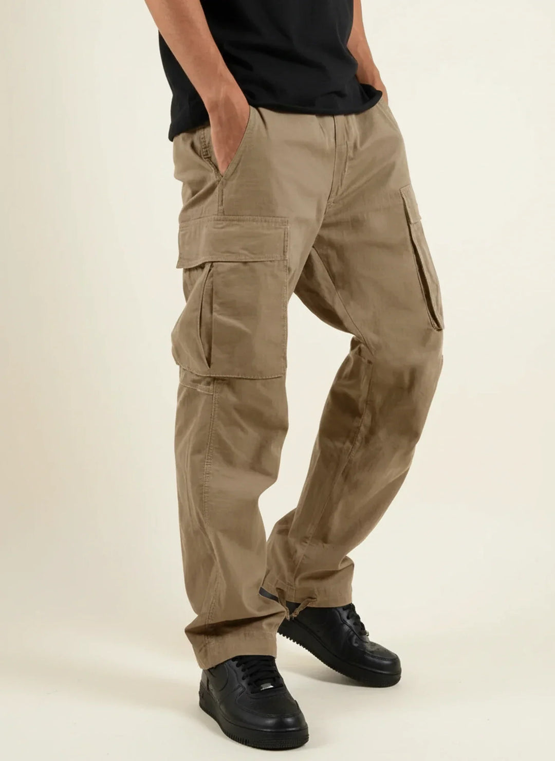 Pantalon cargo noir pour homme, poches multiples et ourlet ajustable. Coupe ample fonctionnelle et confortable.