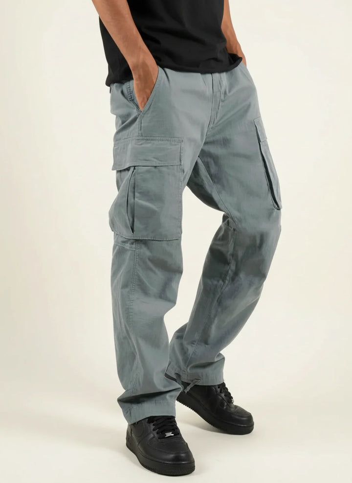 Vêtement homme : Pantalon cargo gris à jambe droite ample, poches pratiques. Style fonctionnel et confortable.