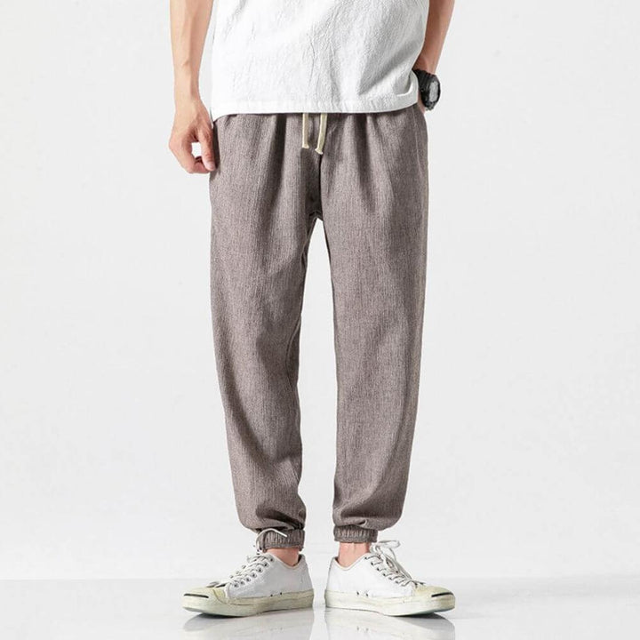 Pantalon respirant homme gris, décontracté. Léger et confortable avec poches fonctionnelles pour l'été.