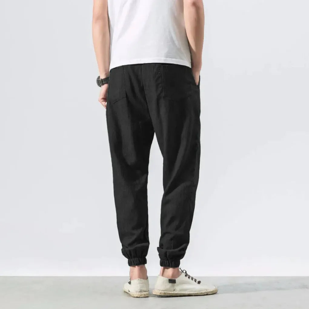 Pantalon léger homme noir avec taille élastique et poches. Ultra-respirant pour un confort d'été optimal.
