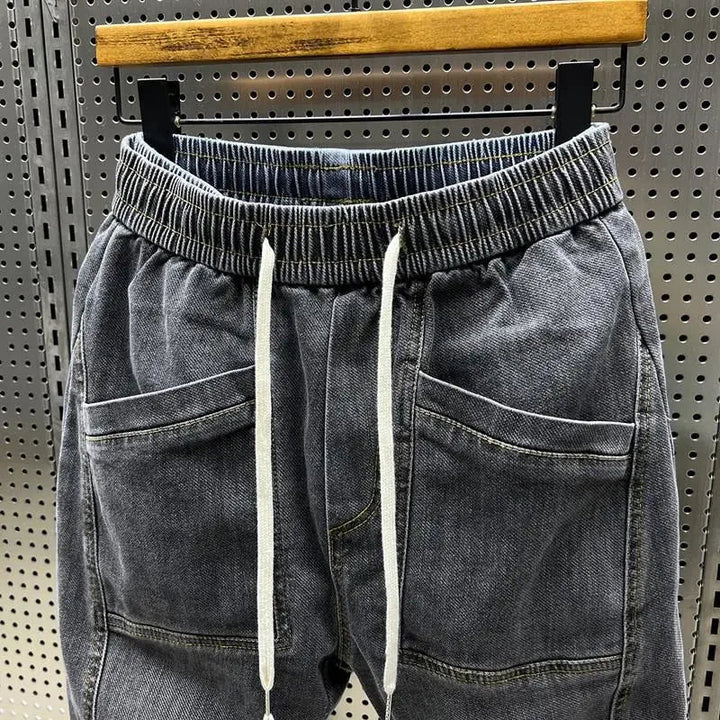 Homme portant pantalon jogger Jiro effet denim, style décontracté et moderne, idéal pour la ville ou loisirs.