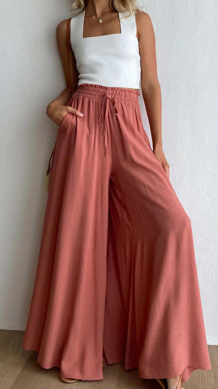 Femme marchant en pantalon large taille haute Tencel, silhouette fluide élégante.