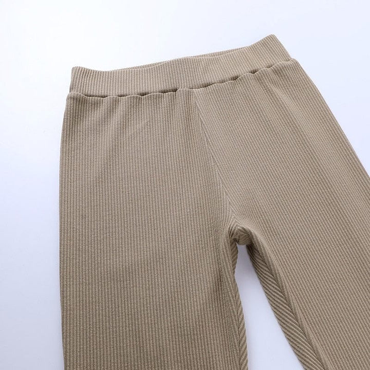 Femme se détendant en legging côtelé taille haute, confort et polyvalence pour ses moments de calme.