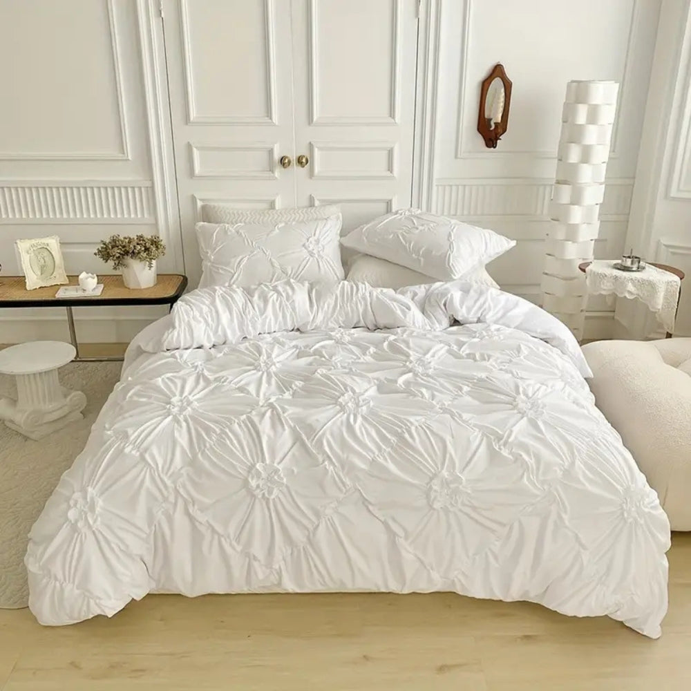 Gros plan sur la parure de couette élégante avec ses motifs à plis pincés pour un lit luxueux.