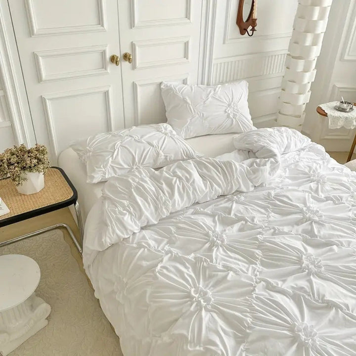 Parure de lit textile douce et luxueuse, avec housse de couette à plis pincés pour un confort optimal.