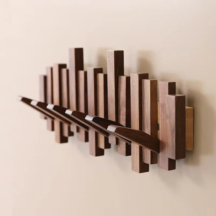 Patère murale design "touches de piano" en bois de noyer, 6 crochets noirs pour un style unique.