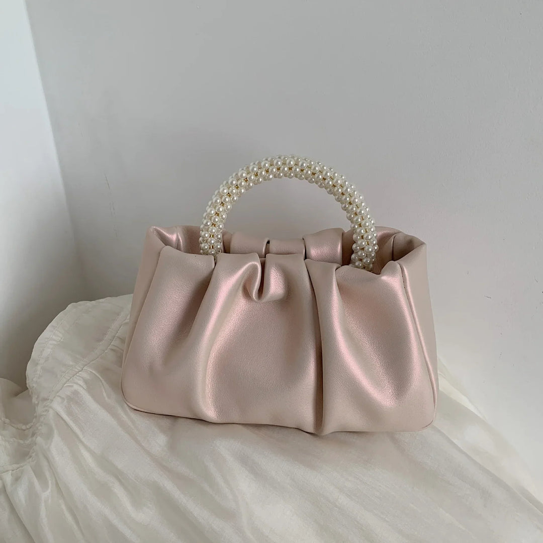 Fermoir doré détaillé du petit sac de soirée femme, style cérémonie distingué.