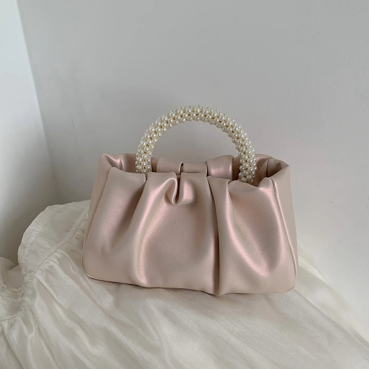 Fermoir doré détaillé du petit sac de soirée femme, style cérémonie distingué.
