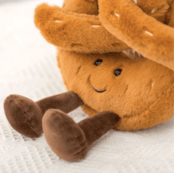 Adorable peluche beignet glacé coloré, jouet doux et réconfortant, idéal pour un câlin gourmand.