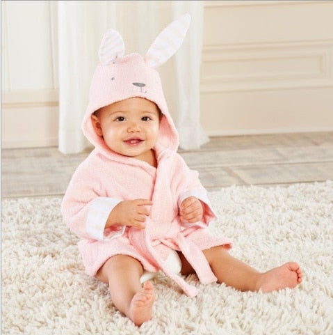 Enfant emmitouflé dans son peignoir de bain bébé doux à capuche animal après le bain.