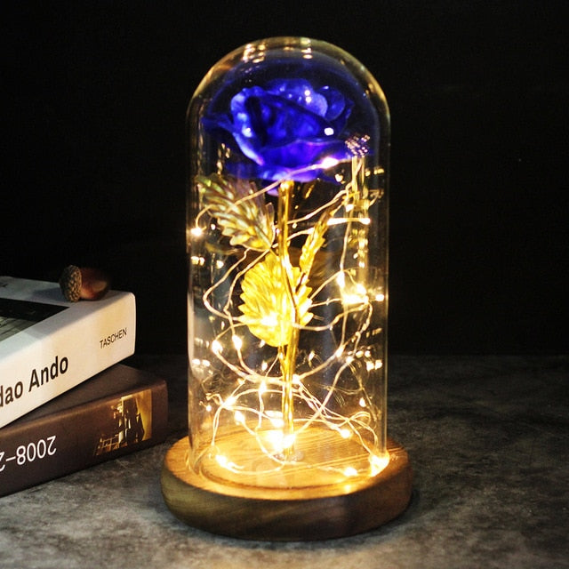 Fleur éternelle rouge sous cloche de verre, éclairage LED doux, décoration intérieure.