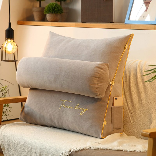 Coussin dorsal ergonomique triangulaire pour canapé, assurant un soutien et un confort de lecture ou relaxation.