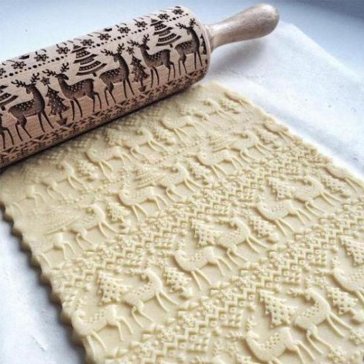 Famille prépare des biscuits de Noël avec un rouleau à pâtisserie décoratif en bois, ambiance festive.