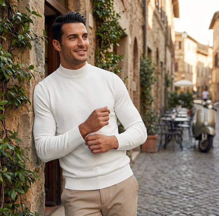 Homme portant un pull col roulé gris chiné, coupe slim élégante. Basique polyvalent pour une tenue hivernale chic.