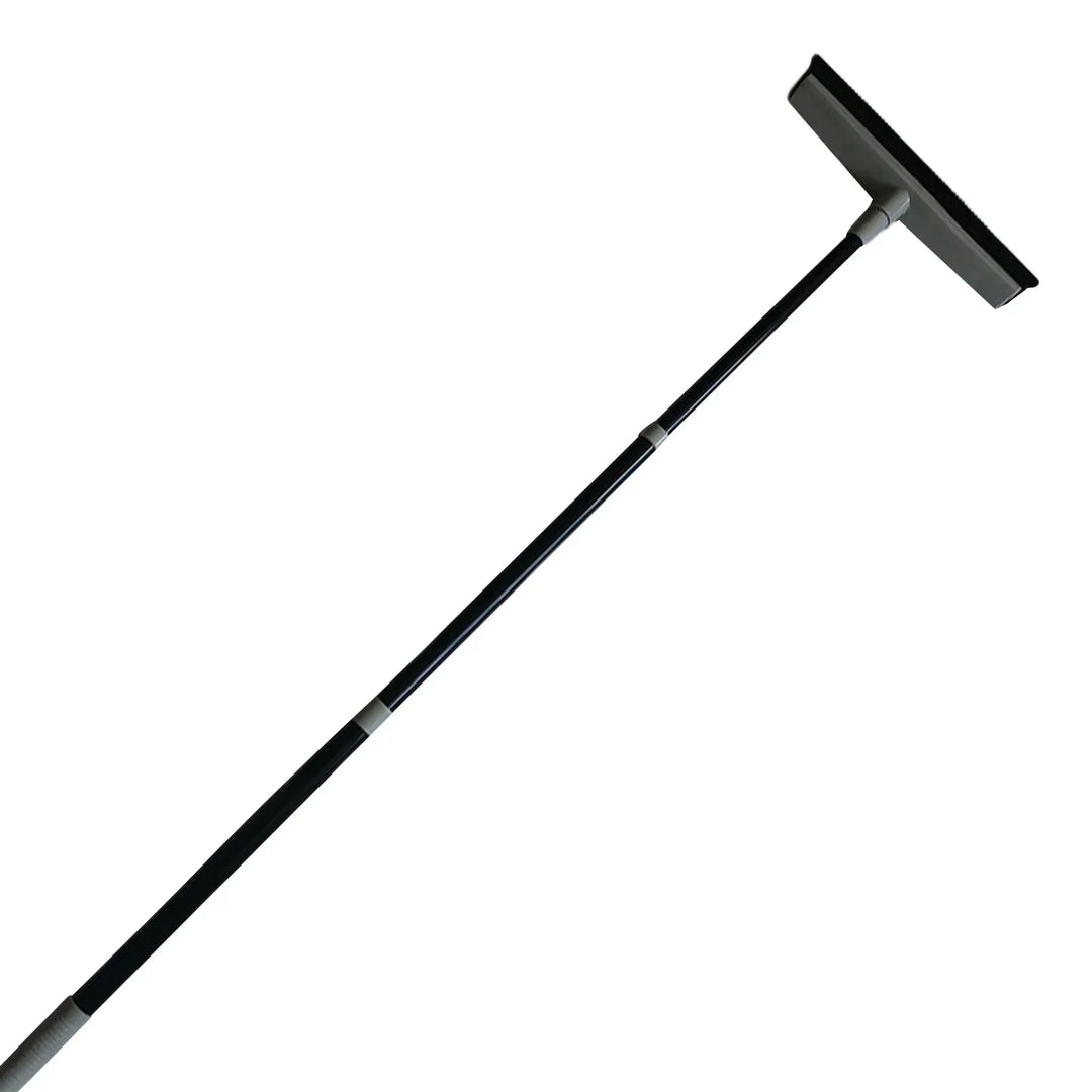 Homme utilisant une raclette de nettoyage électrostatique sur un sol carrelé, ramassant poussière et débris.