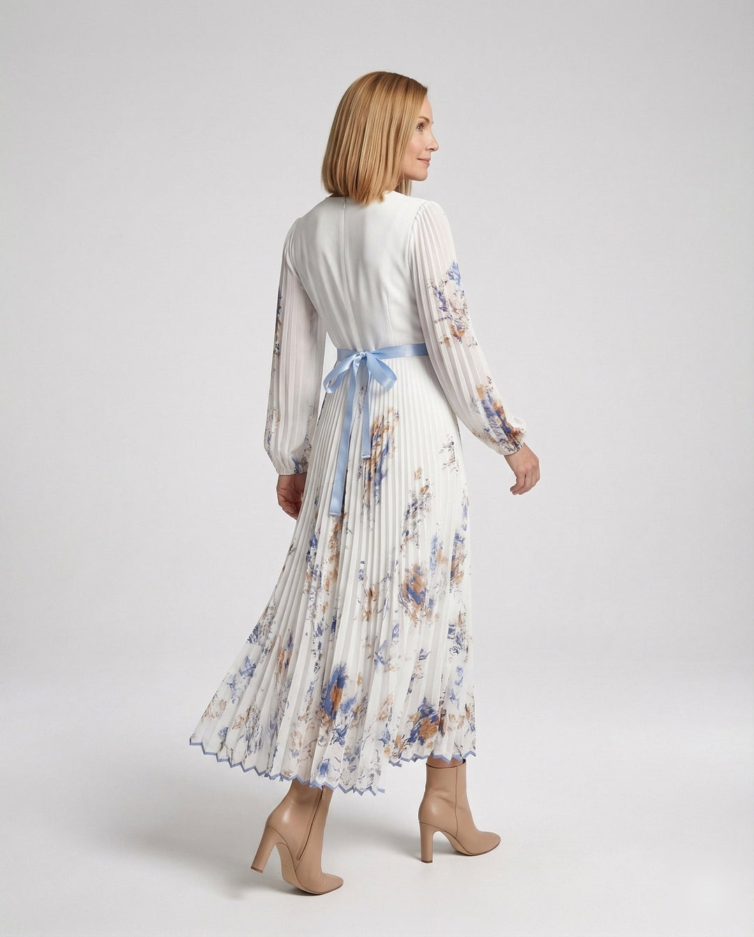 Robe plissée élégante pour femme, coupe longue fluide et sophistiquée, avec encolure croisée.