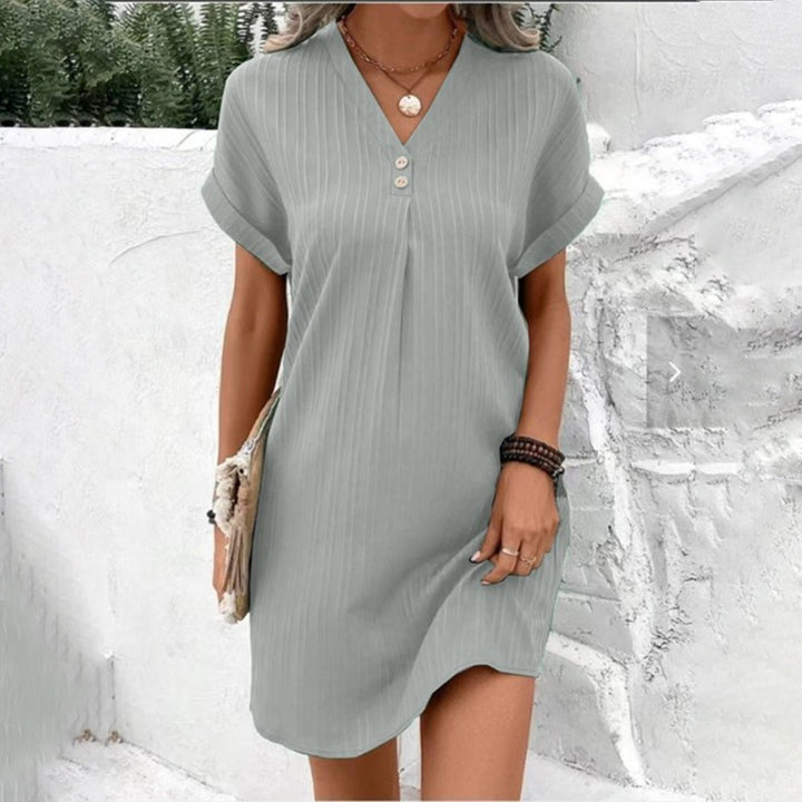 Robe femme courte élégante à col V, coupe chemise, boutonnée devant, manches courtes. Look féminin et polyvalent.