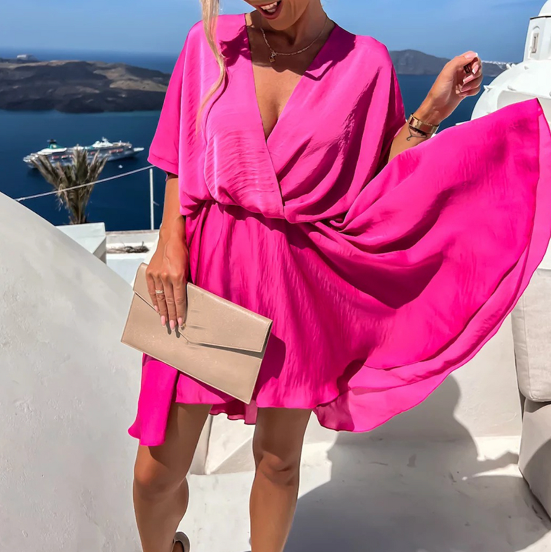 Femme portant une robe courte élégante, col V, taille cintrée. Style estival chic.
