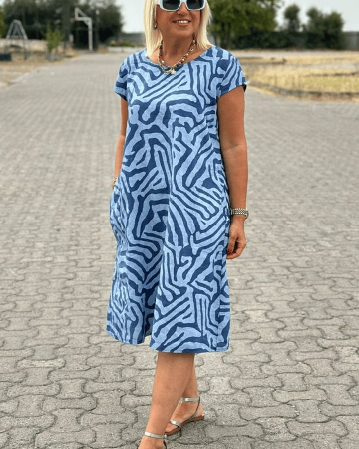 Robe midi col rond femme, design fluide et aéré. Parfaite pour un look d'été relaxant et stylé au quotidien.
