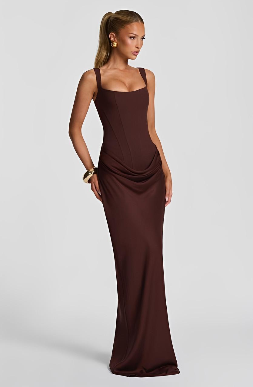 Femme portant une robe longue blanche à bretelles, dos nu, très chic et fluide pour l'été.