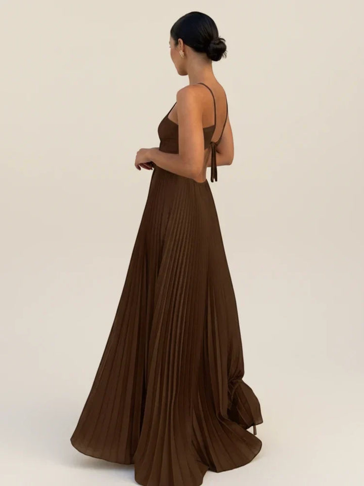 Robe longue plissée fluide femme, encolure américaine et dos nu, ajoutant une touche glamour pour événement chic.