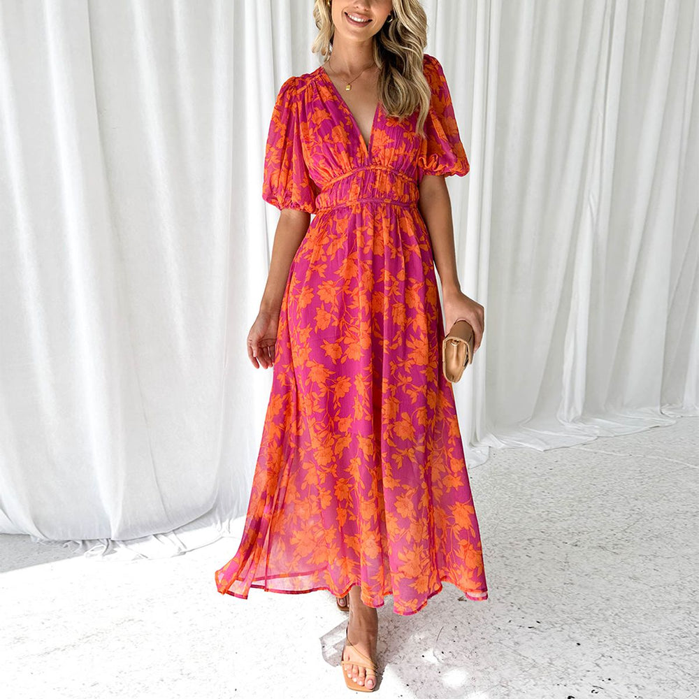 Tenue de soirée femme chic, robe longue fleurie à col V et manches bouffantes. Idéale pour l'été.
