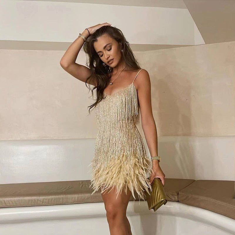 Mini-robe noire à franges avec fines bretelles spaghetti, idéale pour une tenue de soirée élégante.