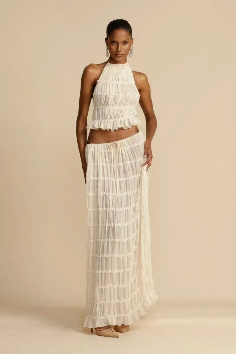 Gros plan sur le tissu chiffon léger et le plissé délicat de l'ensemble femme Calysta, très chic.