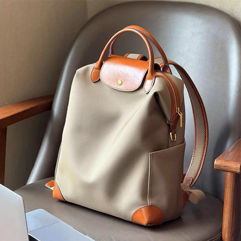 Sac à dos femme bicolore taupe et crème en cuir, quincaillerie dorée. Style urbain chic et moderne.