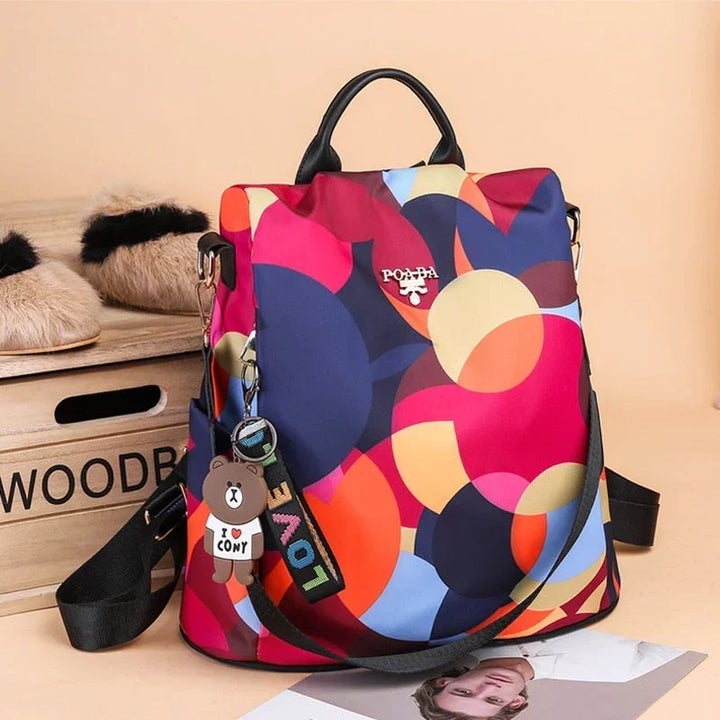 Sac à dos antivol femme, design élégant rouge/multicolore. Idéal pour sécurité, voyage et usage quotidien.