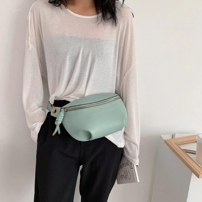 Femme portant un sac banane en cuir noir élégant, accessoire mode pratique au quotidien.