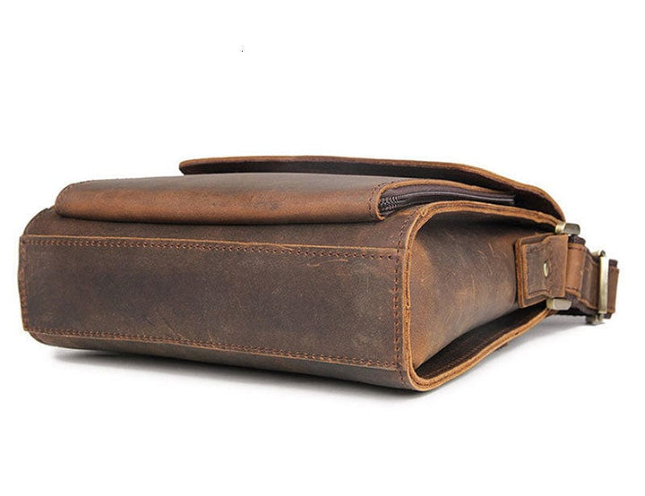 Vue détail: fermeture et texture du cuir véritable sur ce sac bandoulière homme noir.