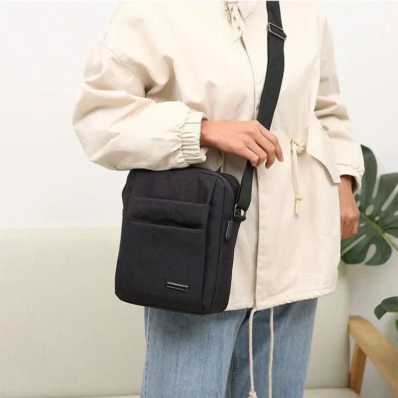 Homme portant sac bandoulière anti-vol, sécurisé et imperméable, traversant la ville avec confiance et style.