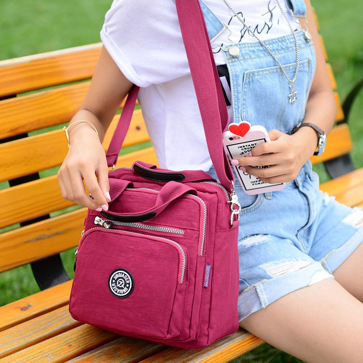 Sac bandoulière imperméable multifonctionnel pour femmes, idéal voyage et protection pluie, style moderne.