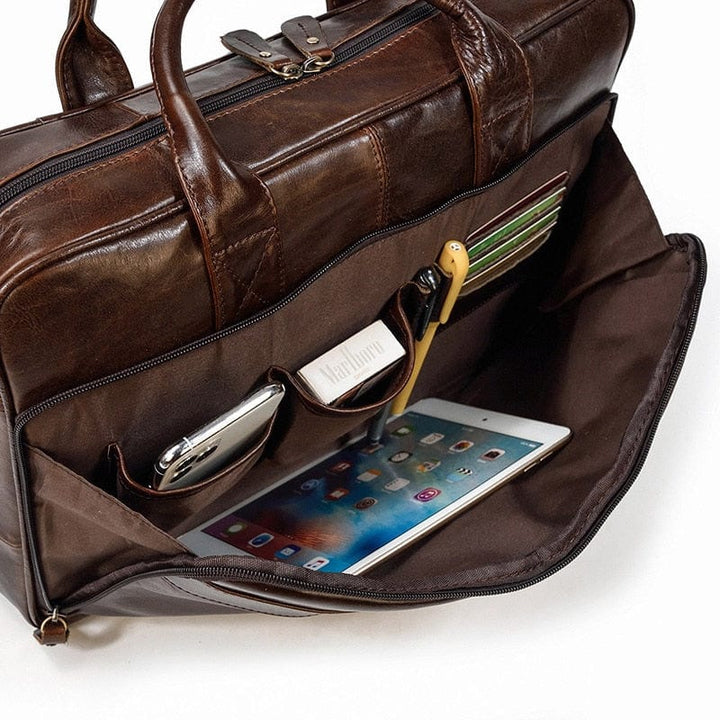 Cartable homme en cuir posé sur bureau, près d'un ordinateur, pour travail.