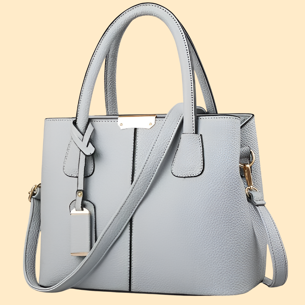 Élégant sac porté main structuré pour femme. Accessoire chic avec pompon. Idéal mode femme.