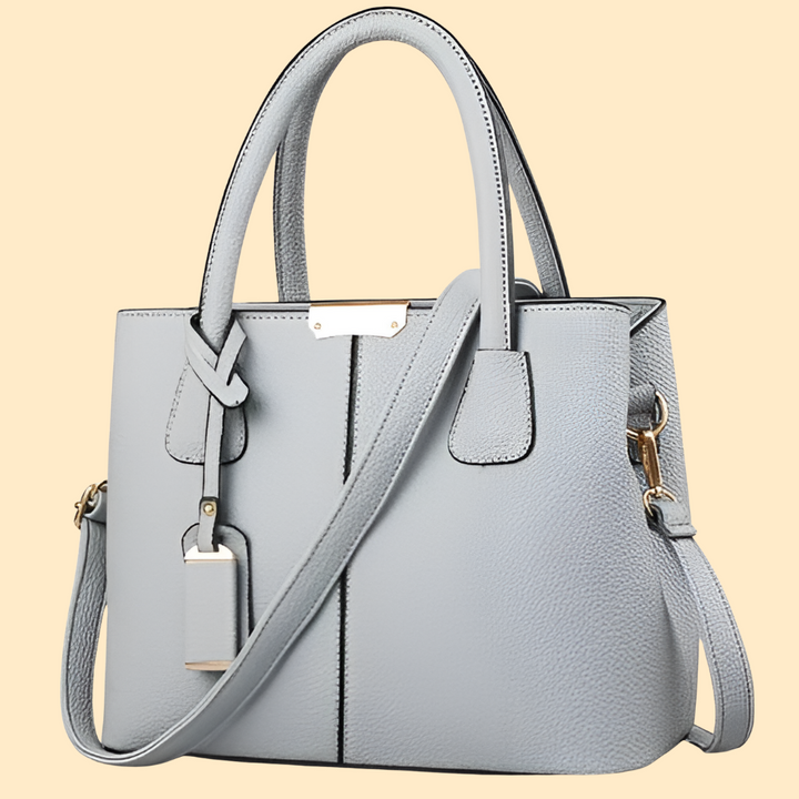 Élégant sac porté main structuré pour femme. Accessoire chic avec pompon. Idéal mode femme.