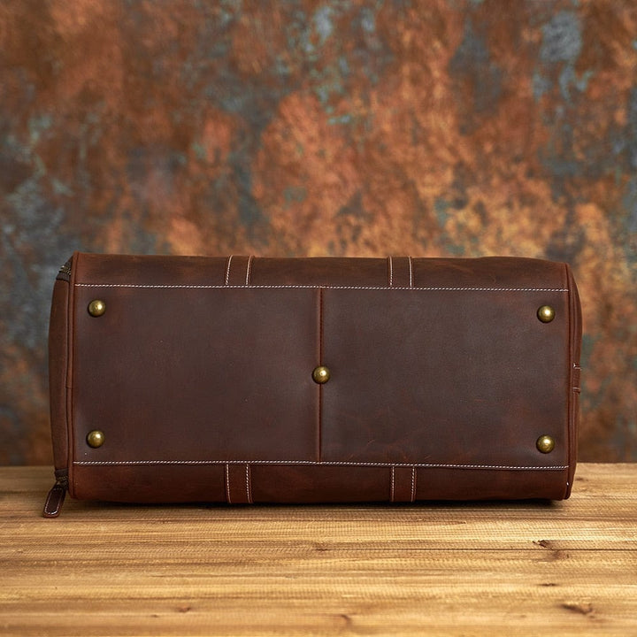Sac de voyage homme cuir vintage, anses solides et bandoulière amovible. Style intemporel.