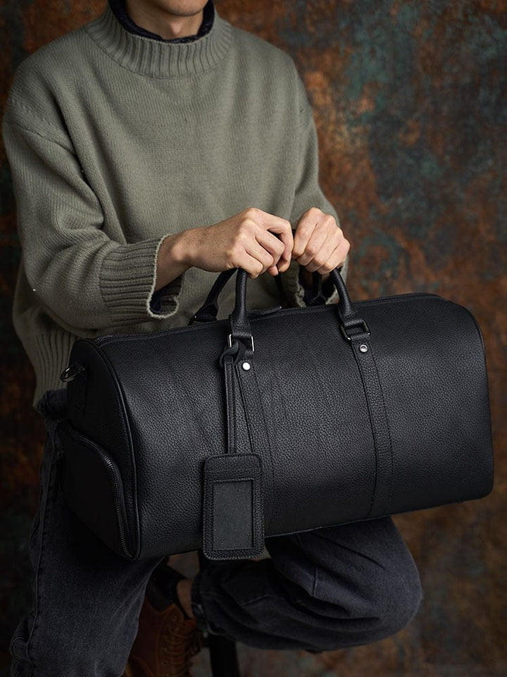 Sac de voyage homme en cuir noir, chic et compact, idéal pour les voyages d'affaires ou week-end.