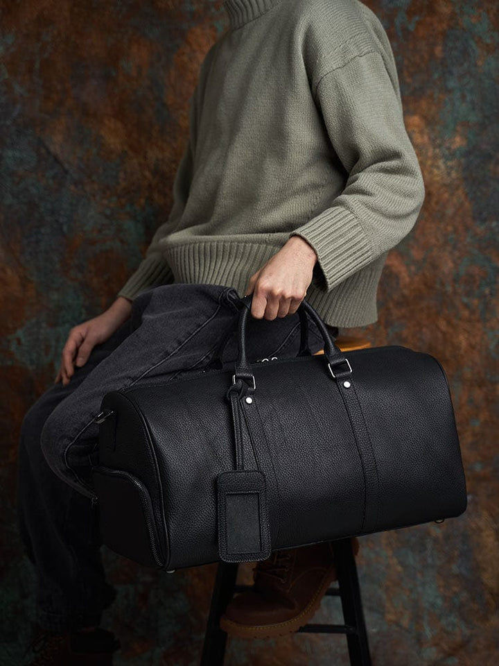 Élégant sac de voyage pour homme en cuir noir, style cabine, conçu pour le business et les week-ends.