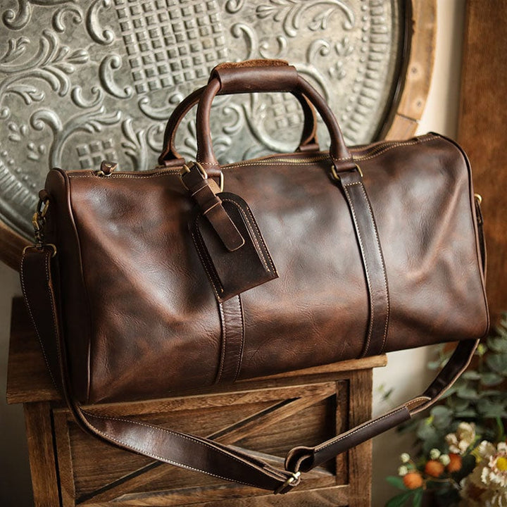 Sac de voyage homme en cuir vintage Kaïs porté. Look stylé et confortable pour un week-end réussi.