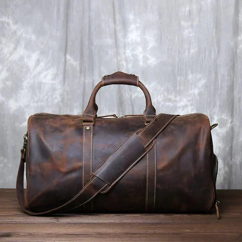 Sac cuir vintage pour homme avec bandoulière, parfait pour voyage ou week-end. Robuste et intemporel.