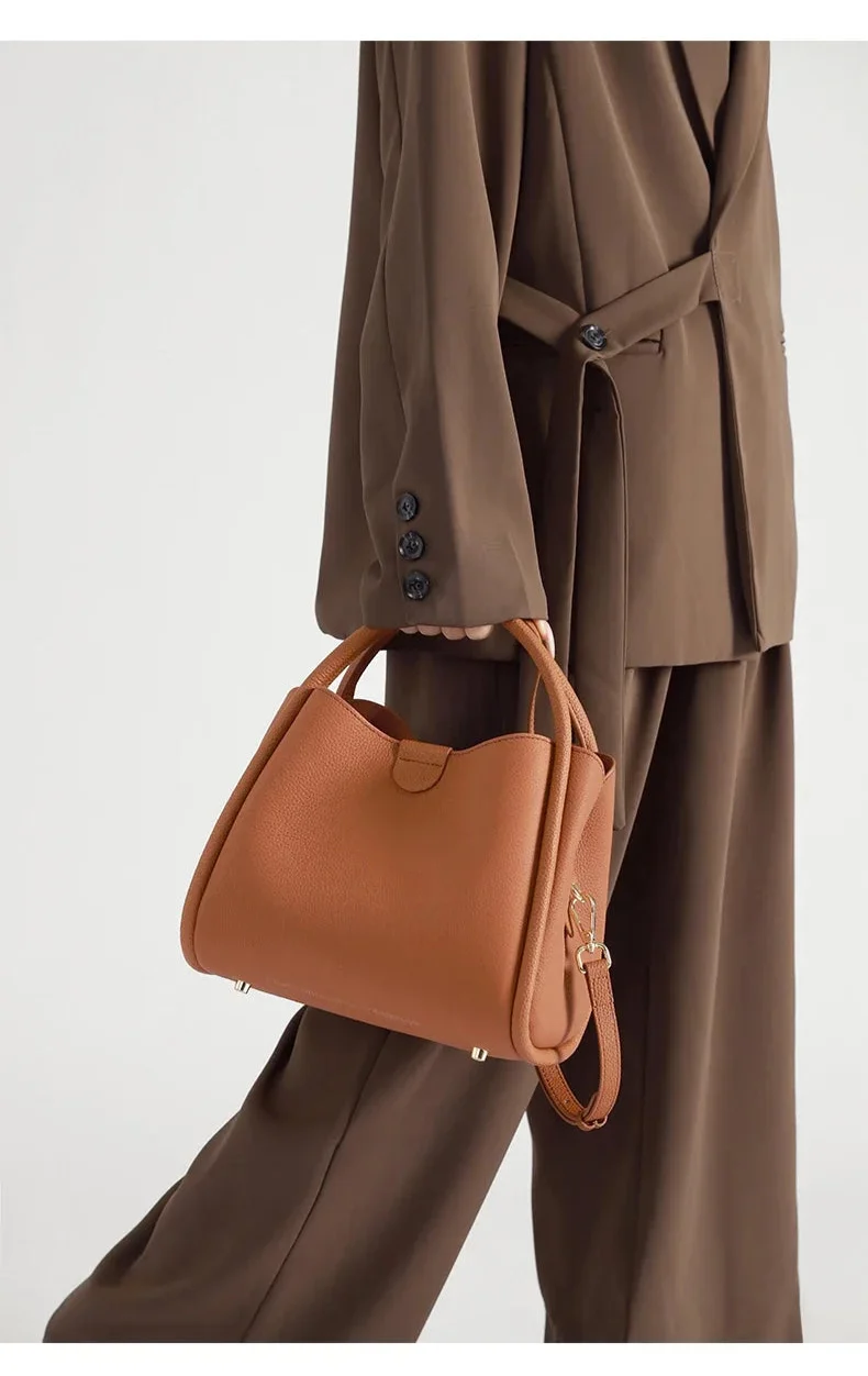 Sac à main chic pour femme en similicuir noir, avec bandoulière ajustable, style moderne.
