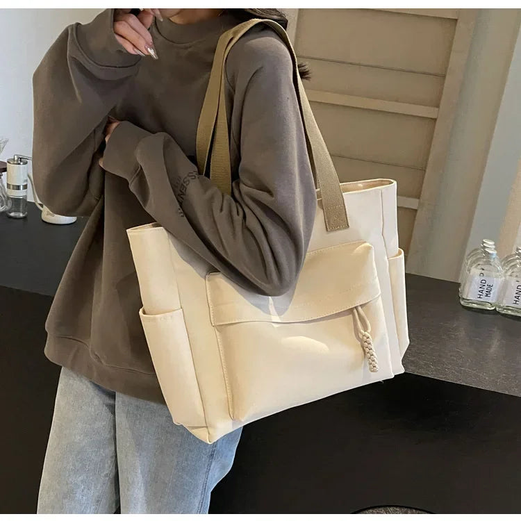 Intérieur du sac de cours en toile, montrant l'organisation et les compartiments pour les fournitures.