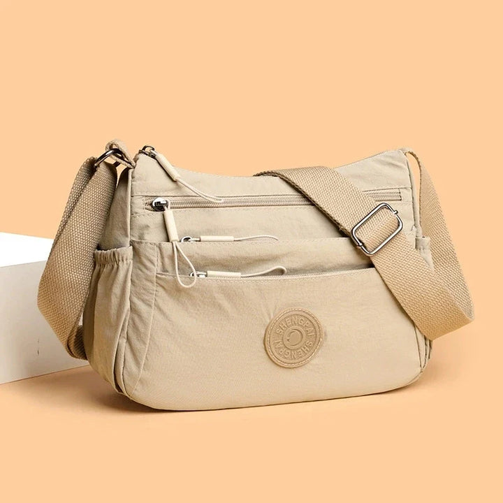 Sac besace moderne et léger pour femme, doté d'une bandoulière, accessoire pratique et organisé.