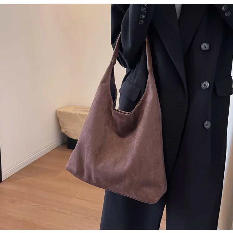 Sac besace femme en daim couleur café, porté épaule, élégant et pratique au quotidien.
