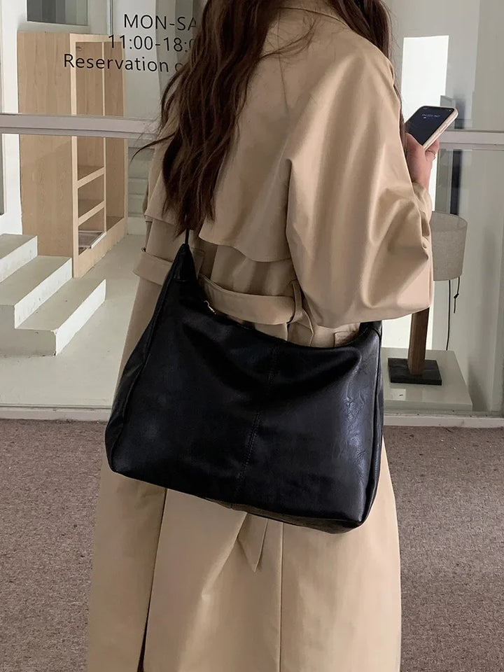 Sac à épaule femme élégant en similicuir noir. Accessoire mode, parfait pour le travail ou les sorties. Tendance.
