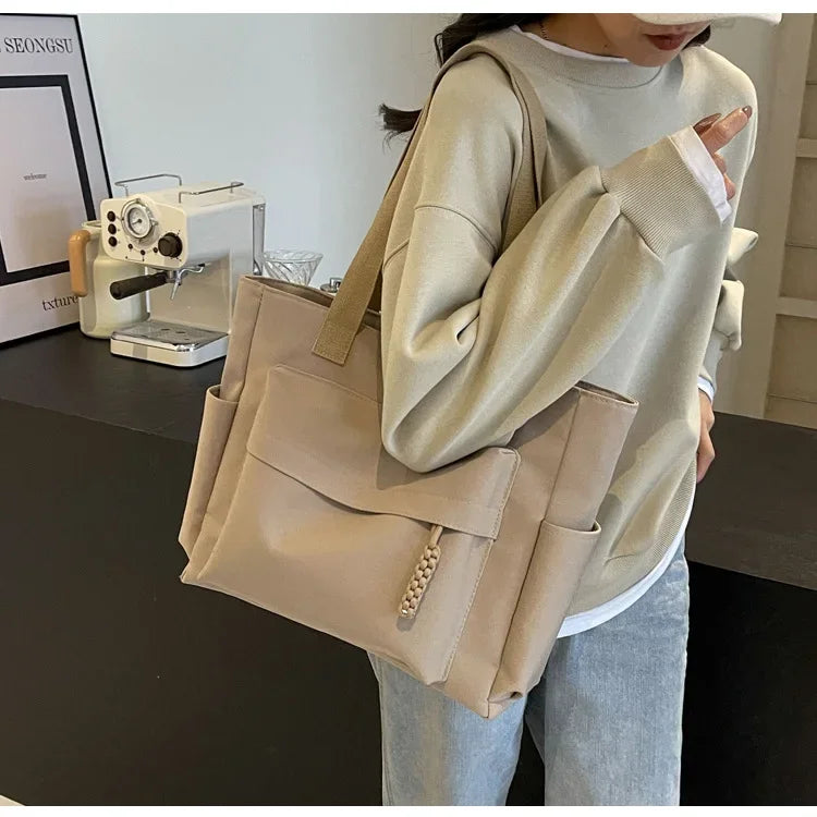 Sac de cours femme en toile beige, idéal pour étudiante, poignées robustes pour un transport facile.