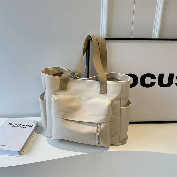 Sac de cours femme en toile, avec une étiquette indiquant la marque, un accessoire pratique et stylé.